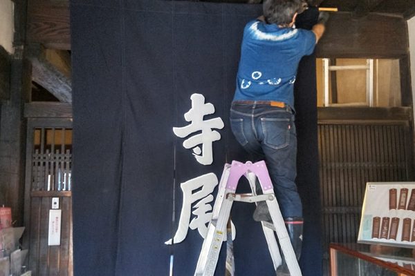 伊勢型紙資料館 寺尾家住宅の看板暖簾を設置している様子